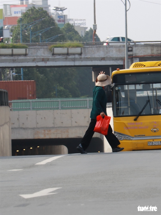 Tại khu vực bến xe An Sương, huyện Hóc Môn, TP.HCM người dân thường di chuyển cắt ngang đầu xe để ra vào bến xe - Ảnh: NGỌC PHƯỢNG