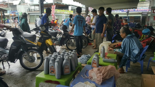 11h30 trưa 7-8 vẫn còn nhiều xe máy được người dân đem tới để thay nhớt và sửa chữa - Ảnh: DƯƠNG NGÂN