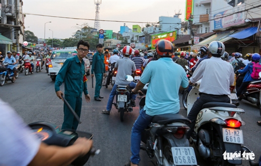 Cơ quan chức năng đứng làm dải phân cách để ngăn người dân lấn lên khi kẹt xe - Ảnh: LÊ PHAN