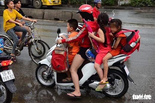 Chở 4 còn không đội mũ bảo hiểm - Ảnh: QUANG ĐỊNH
