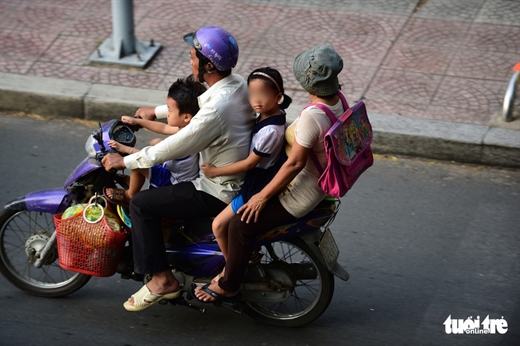 Cả gia đình nhưng chỉ có một người đội mũ bảo hiểm - Ảnh: QUANG ĐỊNH