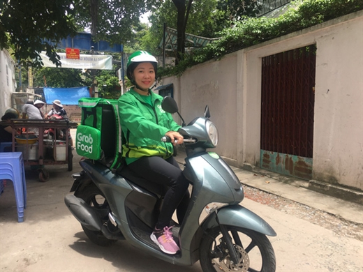 Chị Nguyễn Thị Ngọc Dung đang trên đường đi giao thức ăn cho khách hàng - Ảnh: MINH PHƯỢNG
