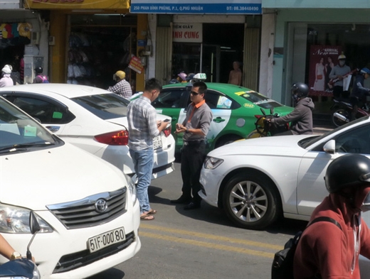 Một vụ va chạm giao thông ở quận Phú Nhuận, TP.HCM, hai tài xế đã ôn hòa, lịch sự trao đổi số điện thoại và chụp ảnh giấy tờ xe, sau đó giao cho bảo hiểm giải quyết - Ảnh: T.T.D.