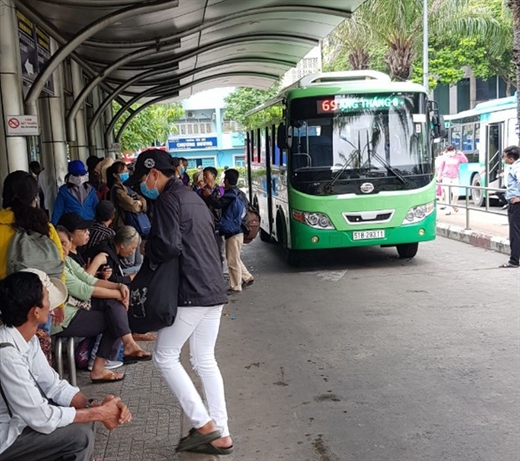 Hành khách chờ xe buýt ở TP.HCM - Ảnh: TTO