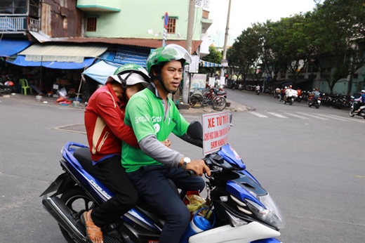 Anh Quí cố gắng giảm ga, chạy rất chậm để đảm bảo an toàn cho bà cụ ngồi phía sau - Ảnh: NGỌC PHƯỢNG