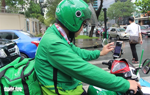 Hình ảnh quen thuộc của tài xế công nghệ với điện thoại thông minh cài app chỉ đường - Ảnh: MY LĂNG